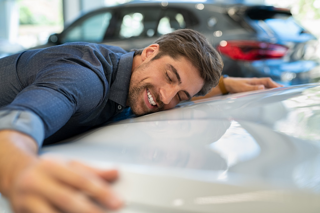 a man hugging his car